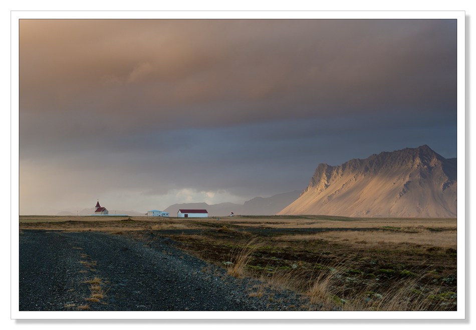 Landscape Photograph, Fáskrúðarbakkakirkja, church with sun dappling on the mountain, rain, waiting for the light, Iceland